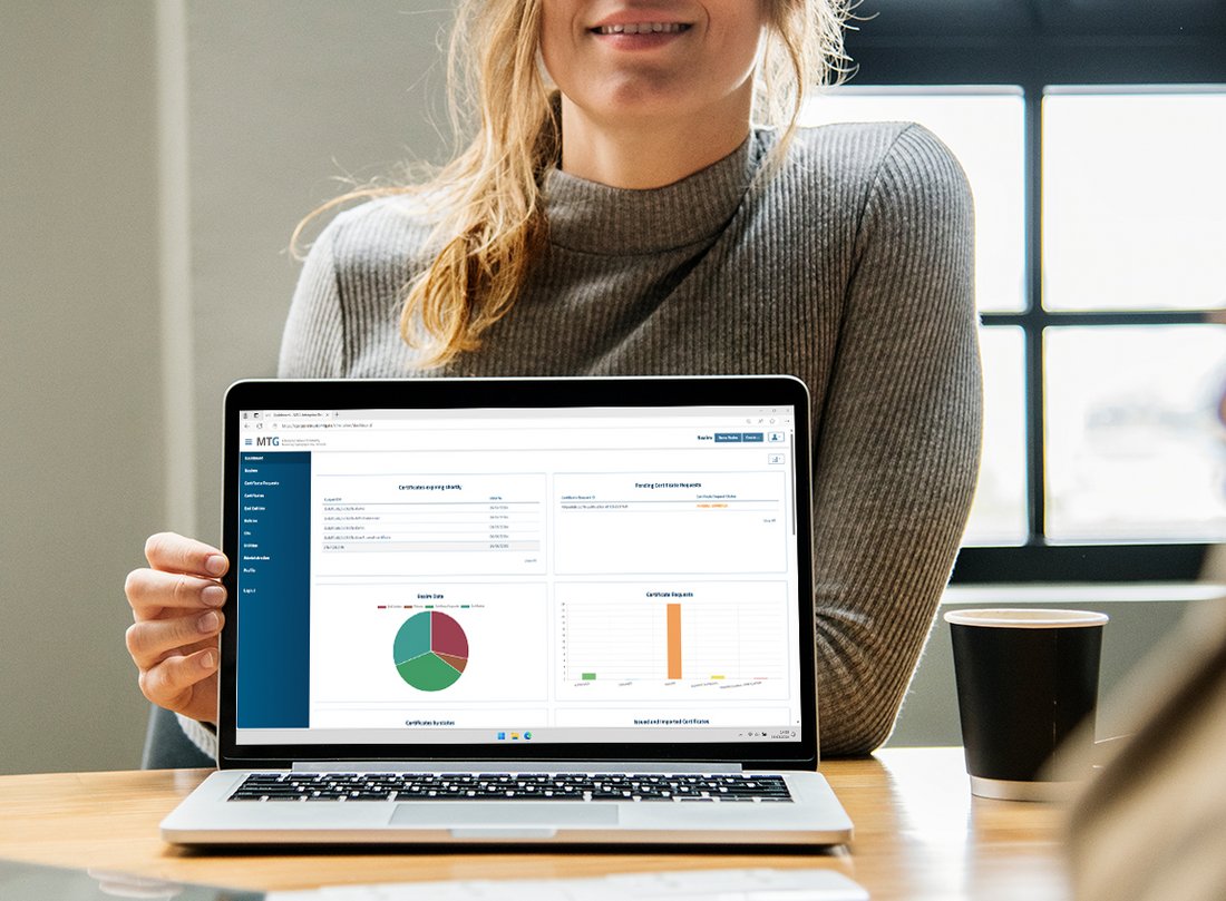 Oberfläsche der 360° Managed PKI & CLM – PSW GROUP Frau hält aufgeklappten Laptop mit Screen der Verwaltungsoberfläche der 360° Managed PKI & CLM in die Kamera.